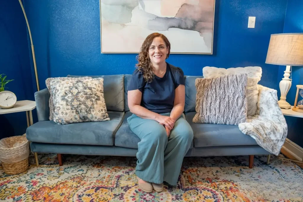 Therapist Suzanne Meli, MA sitting on a couch