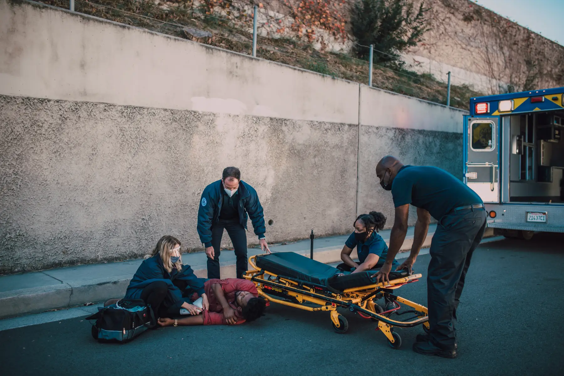 Paramedics helping an injured person lying on the ground
